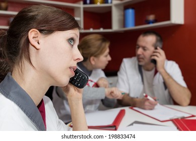 Busy Nurse Staff Is Phoning, Sitting On A White Table