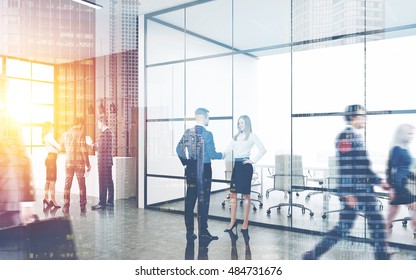 Busy Office Interior. Group Of Colleagues Are Standing Near Reception Counter. Pair Of People Shaking Hands. Concept Of Business Environment. Toned Image