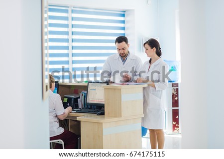 Busy reception in a hospital with doctors and receptionists