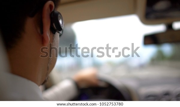 Busy rich man driving car to work, urban traffic,\
transportation service