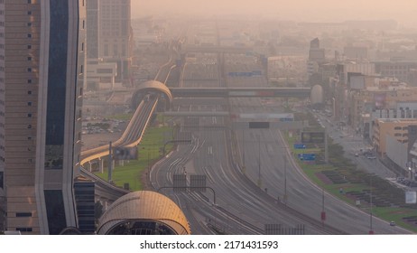 Busy Sheikh Zayed Road Aerial Timelapse, Metro Railway And Modern Skyscrapers Around In Luxury Dubai City With Evening Haze. Heavy Traffic On A Highway With Many Cars. United Arab Emirates