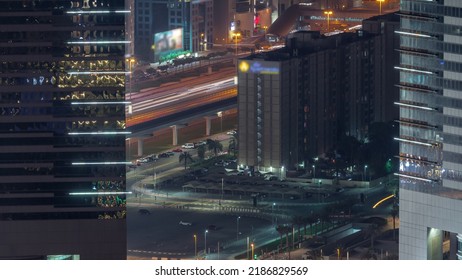 Busy Sheikh Zayed Road Traffic Aerial Night Timelapse, Metro Railway And Modern Skyscrapers Around In Luxury Dubai City, United Arab Emirates