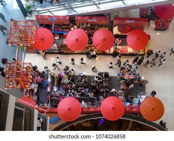 A Busy Shopping Centre In Bangkok, With People And Umbrellas Viewed From Above