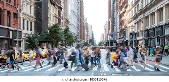 Busy street scene in New York City with groups of people walking across a crowded intersection on Fifth Avenue in Midtown Manhattan NYC