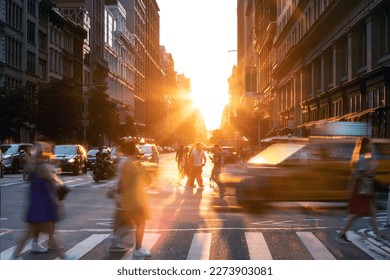 Busy street scene in New York City with yellow taxi driving past crowds of people on 5th Avenue with sunlight shining in the background - Powered by Shutterstock