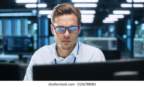 Busy Technical Customer Support Specialist Is Talking On Headset While Working On A Computer In A Call Center Control Dark Room During The Evening. Customer Service Concept