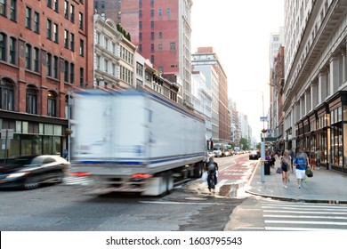 Busy View Of 23rd Street With Delivery Truck Speeding Past The People Walk Down The Sidewalk In Midtown Manhattan, New York City NYC