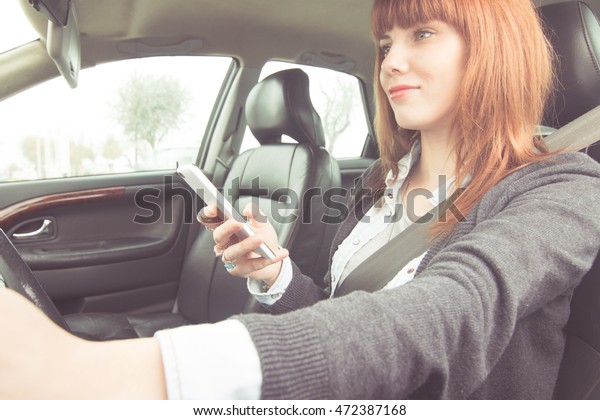 busy woman\
driving car and using smartphone view from outside - business woman\
using telephone while driving\
vehicle