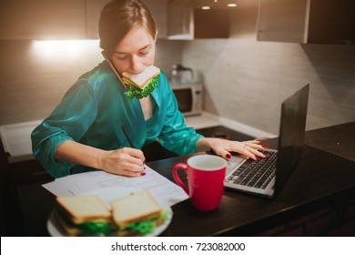 Busy woman eating, drinking coffee, talking on the phone, working on laptop at the same time. Businesswoman doing multiple tasks. Multitasking business person. Freelancer works at night. - Shutterstock ID 723082000