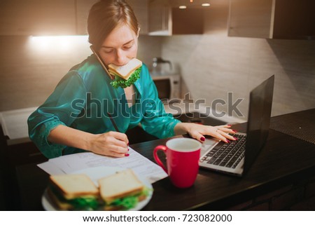 Busy woman eating, drinking coffee, talking on the phone, working on laptop at the same time. Businesswoman doing multiple tasks. Multitasking business person. Freelancer works at night.