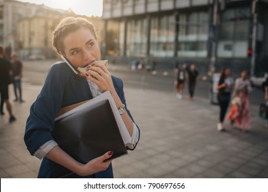 Busy woman is in a hurry, she does not have time, she is going to eat snack on the go. Worker eating, drinking coffee, talking on the phone, at the same time. Businesswoman doing multiple tasks