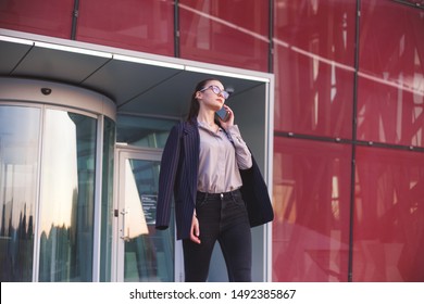 Busy Woman Is Phoning When Leaving An Office Building.