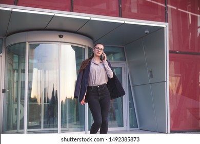 Busy Woman Is Phoning When Leaving Office Building.