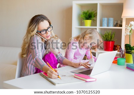 Busy woman trying to work while babysitting two kids