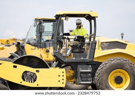busy worker man on construction equipment. construction man worker driving heavy machinery for roadwork. man worker at construction machinery outdoor. man construction worker used vibratory roller