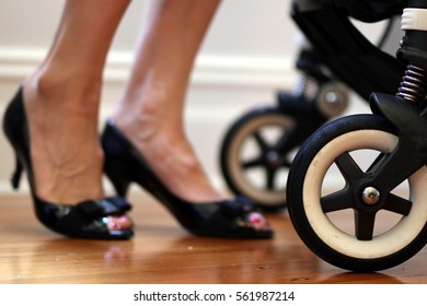 Busy Working Mother Image. Including Closeup Of The Pram Stroller And Mother In Black Leather Corporate Heels Pump Shoes About To Leave For Work. Flexible Work Environment.