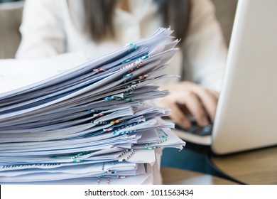 Busy working.Close up stack of documents over confident young freelancer background.