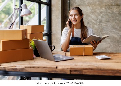 Busy Young Asian Entrepreneur Woman Checking Product On Stock Take Note With Clipboard. Businesswoman Working SME Online At Home. Small Business Owner Start Up Freelance SME Concept.