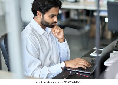 Busy Young Indian Business Man Employee Working Using Laptop, Analyzing Financial Market, Developing Online Project Data, Thinking On Plan Looking At Computer, Doing Accounting Management In Office.