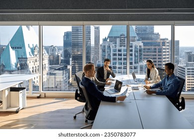 Busy young professional international board executives, diverse team people group discussing financial results managing company project working together in modern meeting room. - Powered by Shutterstock