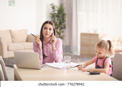 Busy Young Woman With Daughter In Home Office