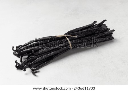 Butch of vanilla beans. Close up dry vanilla sticks on grey background.