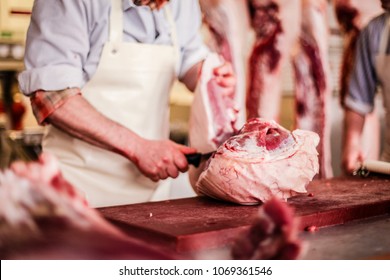 Butcher Cut Raw Meat Of A Pig With A Knife At The Slaughterhouse
