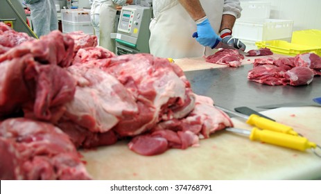 Butcher Cutting Pork Meat in Meat Processing Plant. Fresh raw pork chops in meat factory. Meat processing in food industry. Production line in meat processing plant. - Powered by Shutterstock