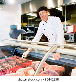 A Butcher At A Fresh Meat Counter Or Deli In A Store