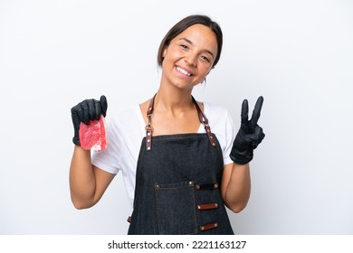 Butcher Hispanic Woman Wearing An Apron And Serving Fresh Cut Meat Isolated On White Background Smiling And Showing Victory Sign