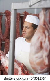 Butcher Holding Slab Of Meat In The Meat Locker