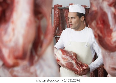 Butcher Holding Slab Of Meat In The Meat Locker