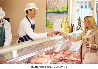 Butcher Serving Customer In Shop