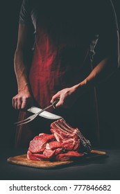 Butcher Sharpening Knife To Cut Raw Meat On Wooden Cutting Board