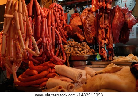 Butcher shop in market stall. Sale of different types of animal meats, sausages, skin, etc.