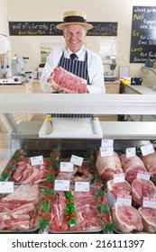 Butcher In Uniform Behind Meat Counter