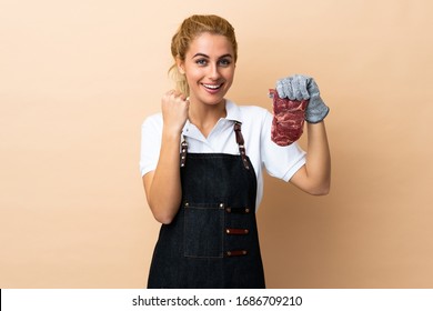 Butcher woman wearing an apron and serving fresh cut meat over isolated background celebrating a victory - Powered by Shutterstock