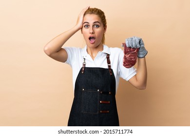 Butcher Woman Wearing An Apron And Serving Fresh Cut Meat Over Isolated Background With Surprise Facial Expression