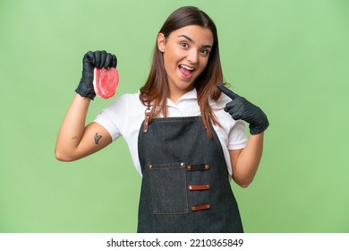 Butcher woman wearing an apron and serving fresh cut meat isolated on green chroma background giving a thumbs up gesture - Powered by Shutterstock