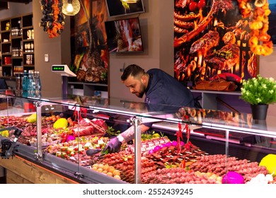 Butchers arranging meat products in window shop. Selection of different cuts of fresh meat raw red in a supermarket. Food industry. - Powered by Shutterstock