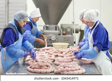 Butchers processing sausages at meat factory. - Powered by Shutterstock