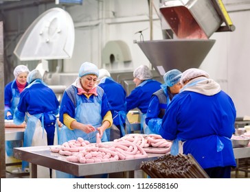 Butchers processing sausages at meat factory. - Powered by Shutterstock