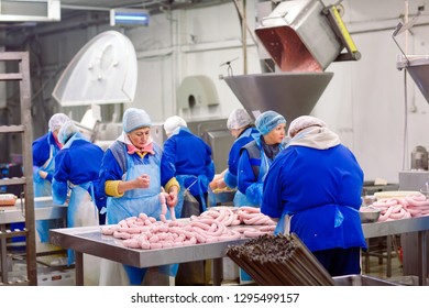 Butchers processing sausages at meat factory. - Powered by Shutterstock