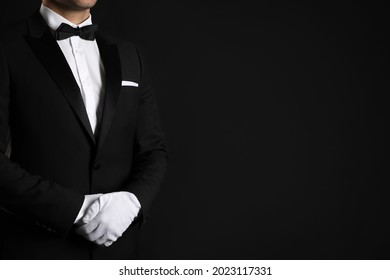 Butler in elegant uniform on black background, closeup. Space for text