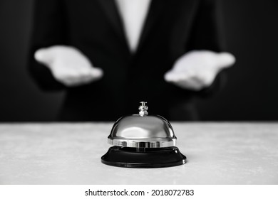 Butler at white desk with service bell, closeup view