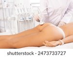 Butt massage with vibration attachement of beauty machine to female patient