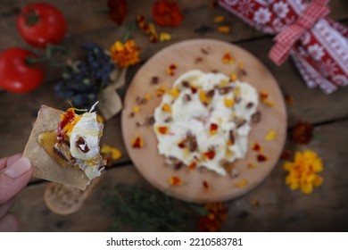 Butter board food trend, cracker with butter and toppings missing a bite, shallow focus on cracker in hand - Shutterstock ID 2210583781