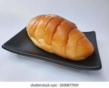 butter bun with sea salt on black plate isolated in white background.