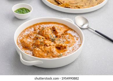 Butter Chicken, An Indian Creamy Chicken Gravy Served In A White Bowl With Roti Or Naan