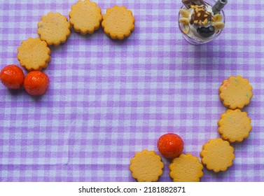 Butter Cookies And Strawberries Arranged On A Purple Table Cloth